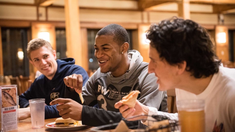 SMCM students enjoying food and conversation at the campus center great room.