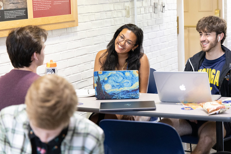 Multiple students having a conversation and laughing while studying in one of our academic buildings.