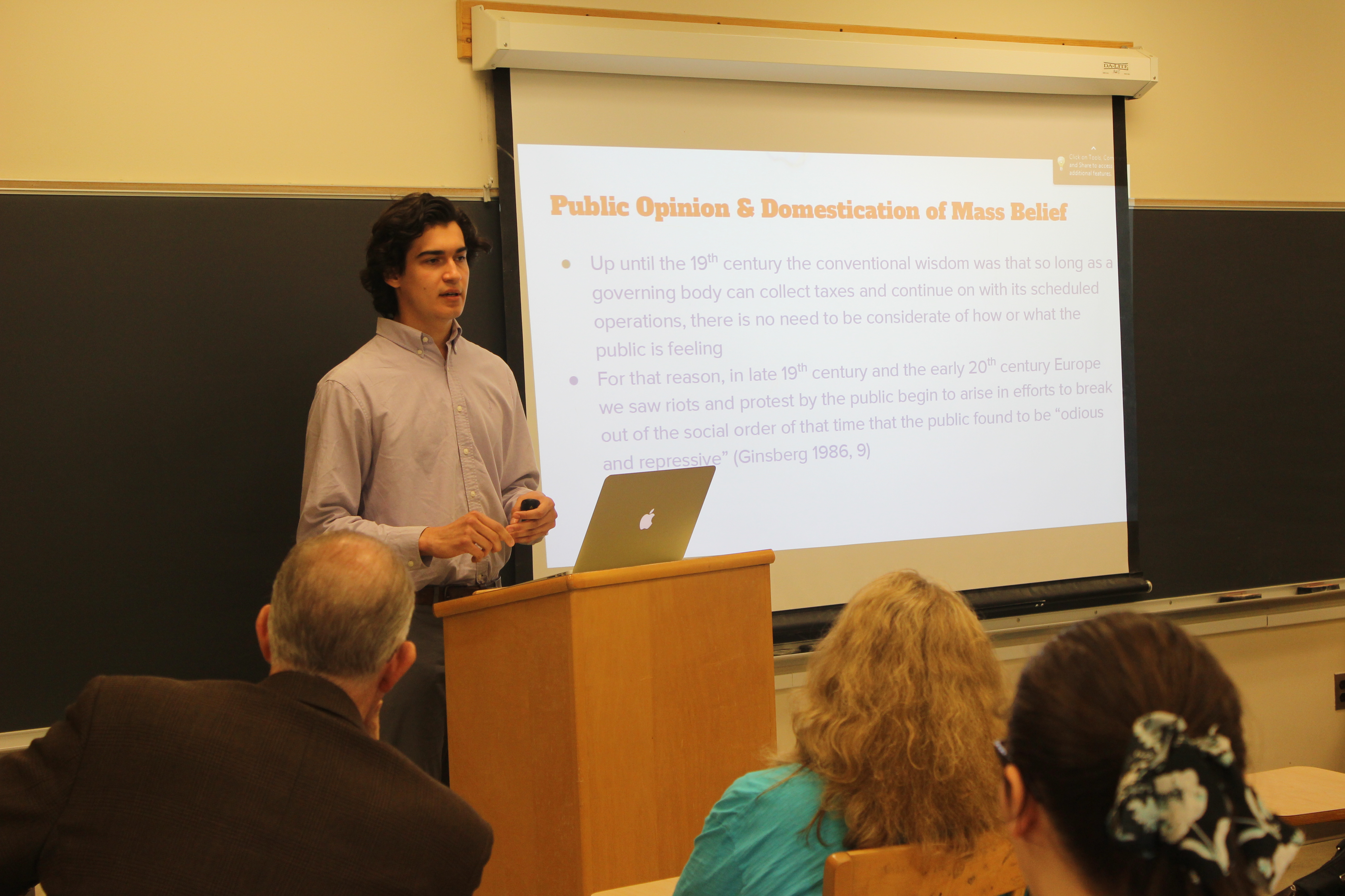 A student presenting his project to his peers in a classroom